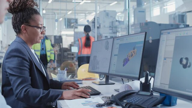 Factory Office Facility: Industrial Engineers Drafting Blueprints of a Heavy Industry Machine Parts on a Computer CAD Software. Modern Technological Industry 4.0 Research and Development Center.