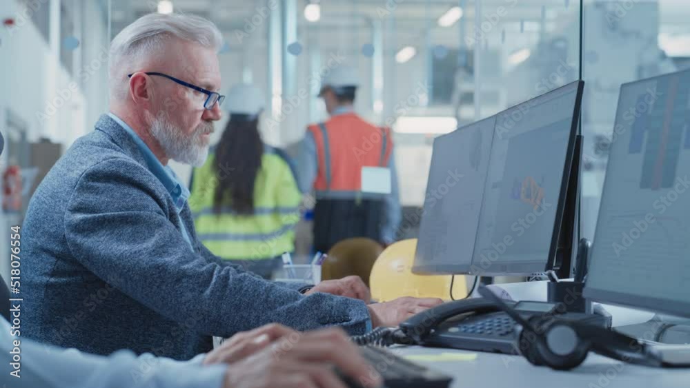 Poster Portrait of a Middle Aged Industrial Engineer Developing Models of a Heavy Industry Machine Parts on Computer 3D Software in a Factory. Modern Technological Research and Development Center. Arc Shot.