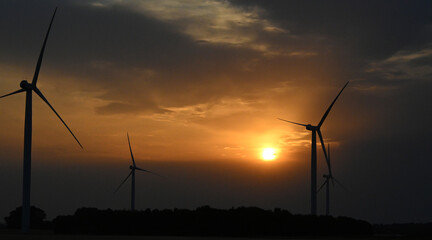 Fototapeta na wymiar wind turbine at sunset, wind farm producing green clean renewable energy