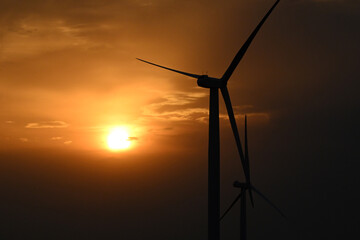 wind turbine at sunset, wind farm producing green clean renewable energy