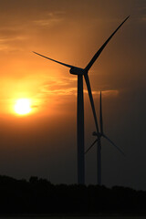 wind turbine at sunset, wind farm producing green clean renewable energy