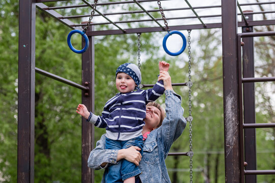 A small child boy and his mother on a children's playground
