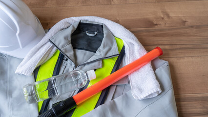 作業服とタオルとプラスチックボトルの水｜建設業・警備業の熱中症対策イメージ