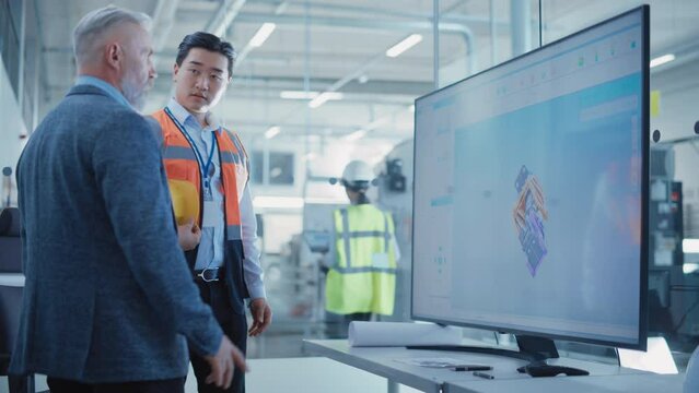 Factory Office Meeting: Facility Director Talking with Chief Engineer in a Conference Room with TV Set. Heavy Industry Employees Discussing Modern Hydraulics Mechanism for Industry Equipment.