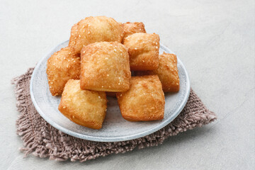 Bolang baling, Odading, fried bread in cubes or blocks, with a light brown crunchy outer skin and sprinkled with sesame seeds, the inside is empty and fluffy, so it looks like a small pillow.
