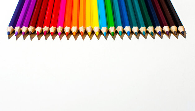 Multi-colored wooden pencils on a white background close-up. Top view with copy space. Stationery