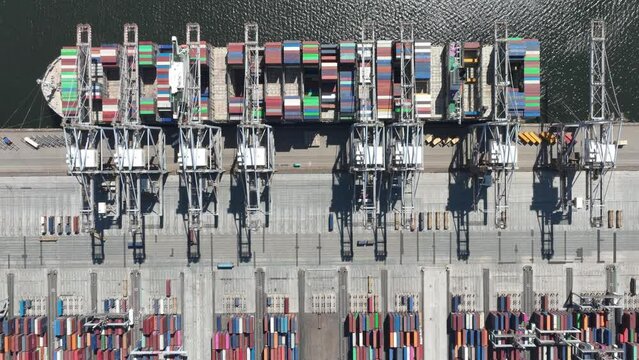 Hyperlapse time lapse container shipping terminal in the port harbour. Import export and loading and unloading of merchandise of a large bulk vessel and cranes. Holland, The Netherlands