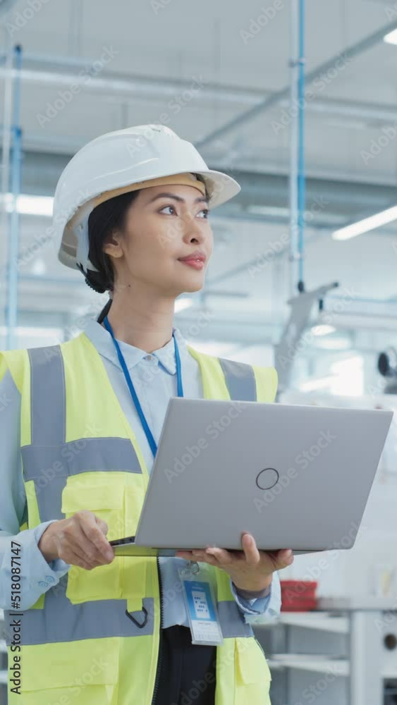 Aufkleber vertical screen: happy asian female engineer in hard hat standing and using laptop computer at elect