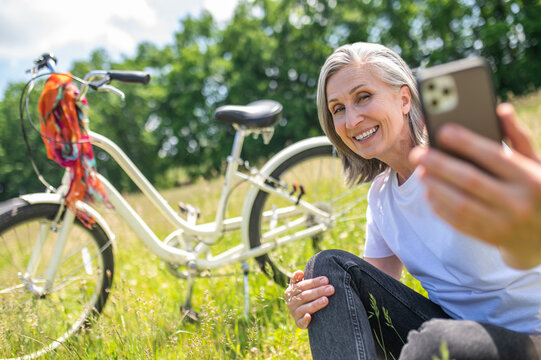 Smiling woman making selfie on her smartphone and looking excited