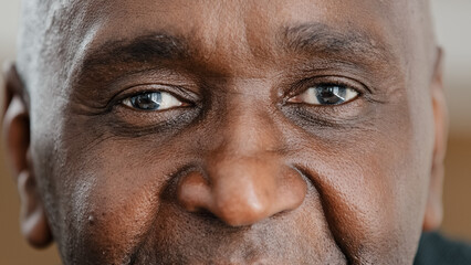 Close up part male face happy elderly African American man smiling with friendly dark black eyes....