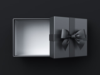 Blank black present box or open gift box with black ribbon and bow isolated on dark black background with shadow minimal conceptual for him 3D rendering