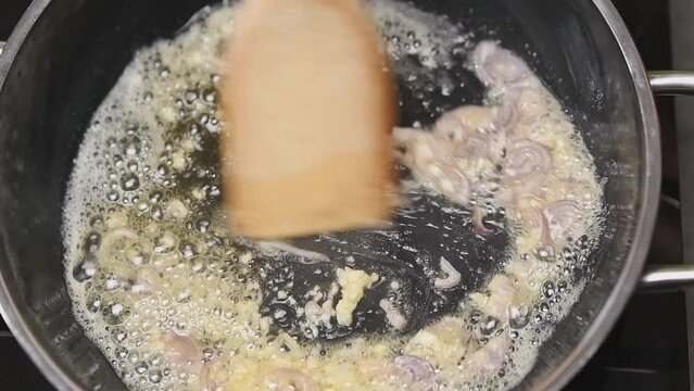 Frying onions and garlic in a frying pan with butter.