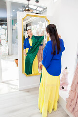 woman is choosing, buying fashionable dress in store, boutique in center, mal
