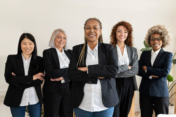 Fototapeta na wymiar diverse women of different ages, multiracial, businesswomen in office, looking at camera with arms crossed, focus on african american woman
