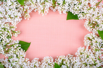 Frame of white lilac flowers on a pink background, copy space