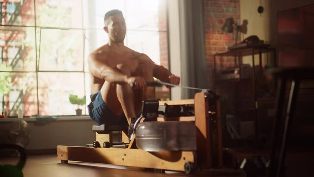 Strong Athletic Black Man Does Shirtless Workout at Home Gym, Exercising on stylish Water Rowing Machine. Lean Fit Muscular Mixed Race Sportsman Staying Healthy, Training. Sweat and Determination. 