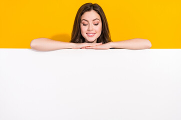 Photo of satisfied funky girl hide behind empty space blank look down isolated on yellow color background