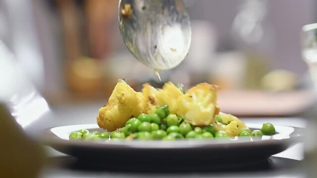 Serving A Salad Of Roasted Cauliflower And Peas.