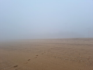 A landscape of a misty beach sandy beach