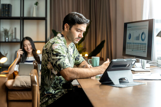 working at home,white caucasian male adult wear casual cloth working with desktop check and analysing business data chart on dining table at home ,home isolate quarantine ideas,work remote concept