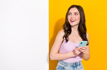 Naklejka premium Portrait of pretty person look interested empty space poster board isolated on yellow color background