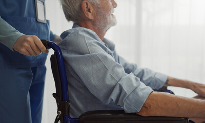 Nurse putting wheelchair with senior man  window. Unhappy senior man having geriatric or depression...