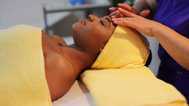 african woman in wellow towel on facial massage	