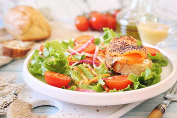 Healthy food. Lettuce salad with red fish, raw vegetables and olive oil. Red fish sandwich with rye bread, poppy seeds and mustard sauce