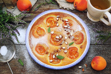 Apricot clafoutis (flan) with almonds, icing sugar dressing and cup of mint tea
