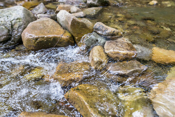 Fototapeta na wymiar Close-up of mountain water with stones in the river.