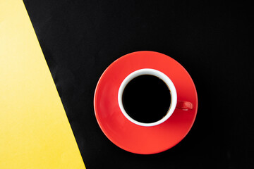 黄色と黒の紙の上の赤いコーヒーカップのコーヒー