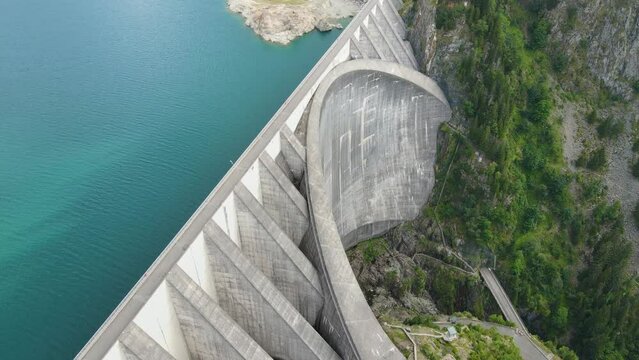 Hydroelectric dam and reservoir lake in French Alps mountains. Renewable energy and sustainable development, low CO2 footprint against global warming, hydropower generation. Aerial video footage.