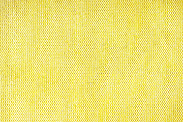 Close-up texture of natural yellow coarse weave fabric or cloth. Fabric texture of natural cotton or linen textile material. Blue canvas background. Decorative fabric for upholstery, furniture, walls