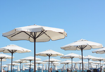 Beautiful white beach umbrellas against blue sky