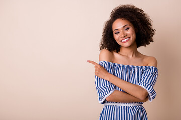 Portrait of stunning cute girl toothy smile direct finger empty space isolated on beige color background