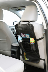Black car seat organizer for babies, on a car interior