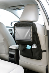 Black car seat organizer for babies, on a car interior