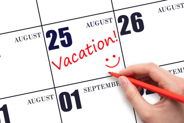 A hand writing a VACATION text and drawing a smiling face on a calendar date 25 August. Vacation...