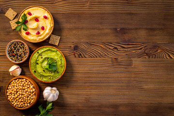 Obraz na płótnie Canvas Colorful hummus in bowls flatlay. Healthy vegetarian meal