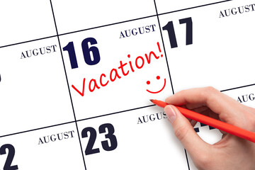 A hand writing a VACATION text and drawing a smiling face on a calendar date 16 August. Vacation...