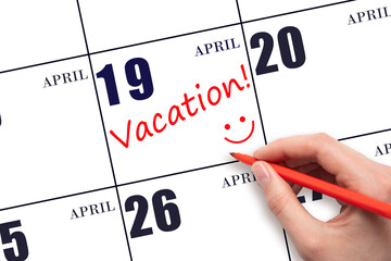 A hand writing a VACATION text and drawing a smiling face on a calendar date 19 April. Vacation...
