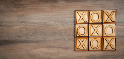 Wooden X, O game on wooden background.