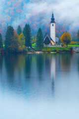 Obraz premium famous tourist destination the Saint John the Baptist church on the shore of gorgeous Bohinj lake in Slovenia