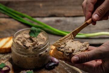 Woman hands spread bread with beans paste, Mexican cuisine pate of beans in glass jar. healthy vegetarian food, top view