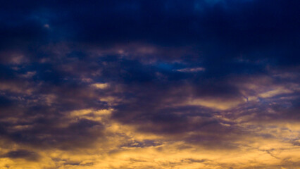 Naklejka na ściany i meble Magnifiques teintes orangées sous un ciel voilé, pendant le coucher du soleil