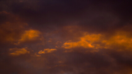 Fototapeta na wymiar Magnifiques teintes orangées sous un ciel voilé, pendant le coucher du soleil
