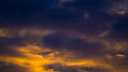 Fototapeta premium Magnifiques teintes orangées sous un ciel voilé, pendant le coucher du soleil