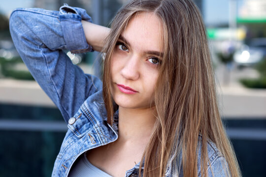 portrait of a teenage girl 16 years old with long hair in a denim jacket