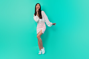 Fototapeta na wymiar Full size portrait of cheerful cute vietnamese lady finger touch chin look empty space think isolated on teal color background
