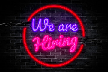 We are hiring text for the job Neon banner on the brick wall background and light signboard.